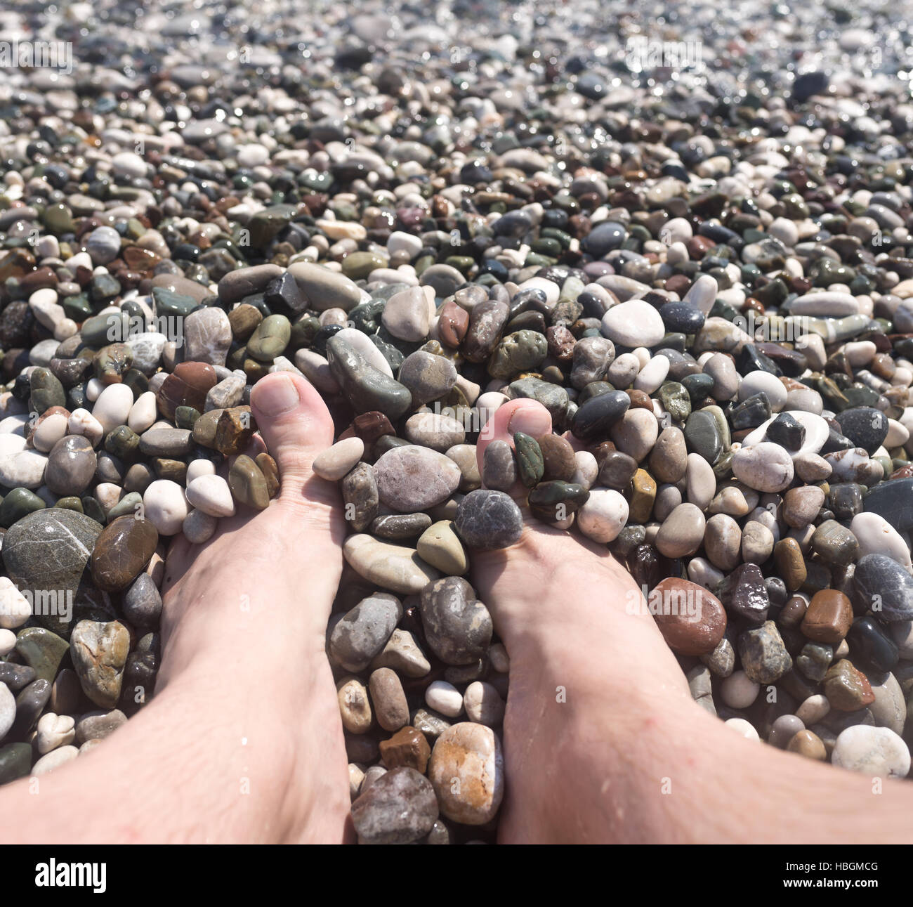 male feet and pebbles Stock Photo