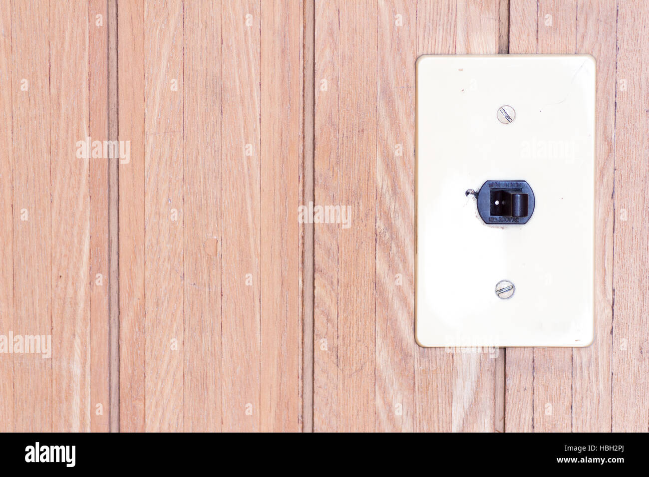 Japanese retro electrical switch on the wooden wall l as the switch set on with a copyspace on the left Stock Photo