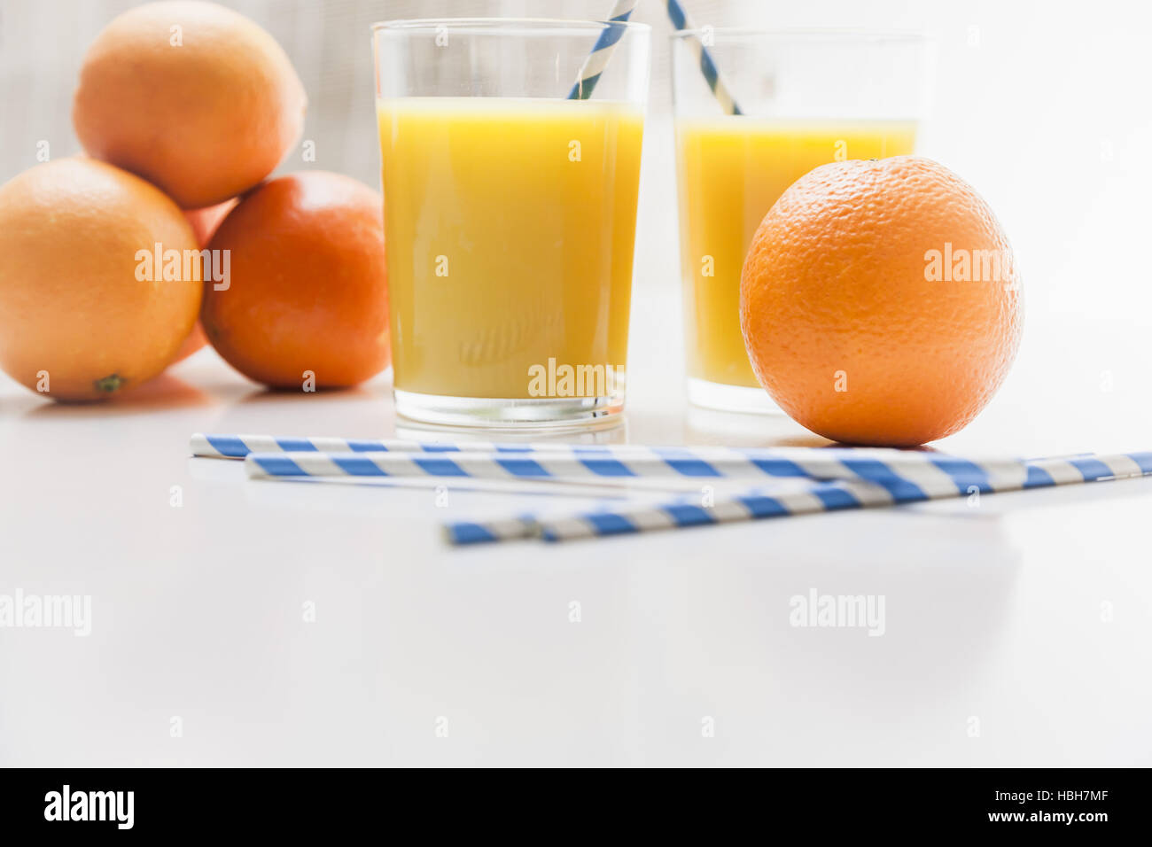 Orange juice backgrounded by oranges Stock Photo Alamy