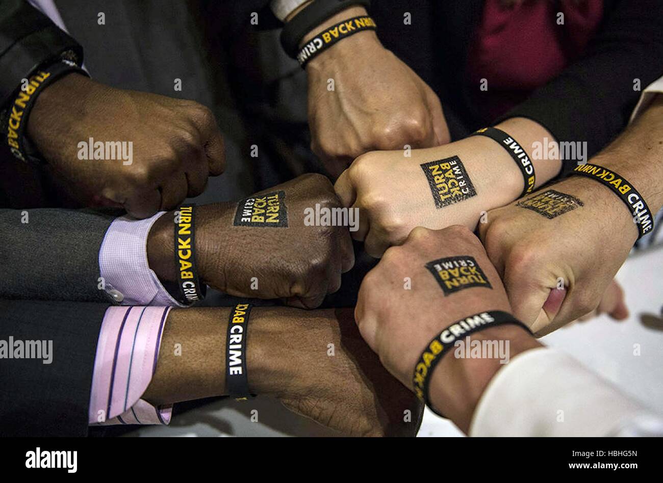 Turn Back Crime campaign bands on seven hands of supporters of Shah Rukh Khan in London, England, UK Stock Photo
