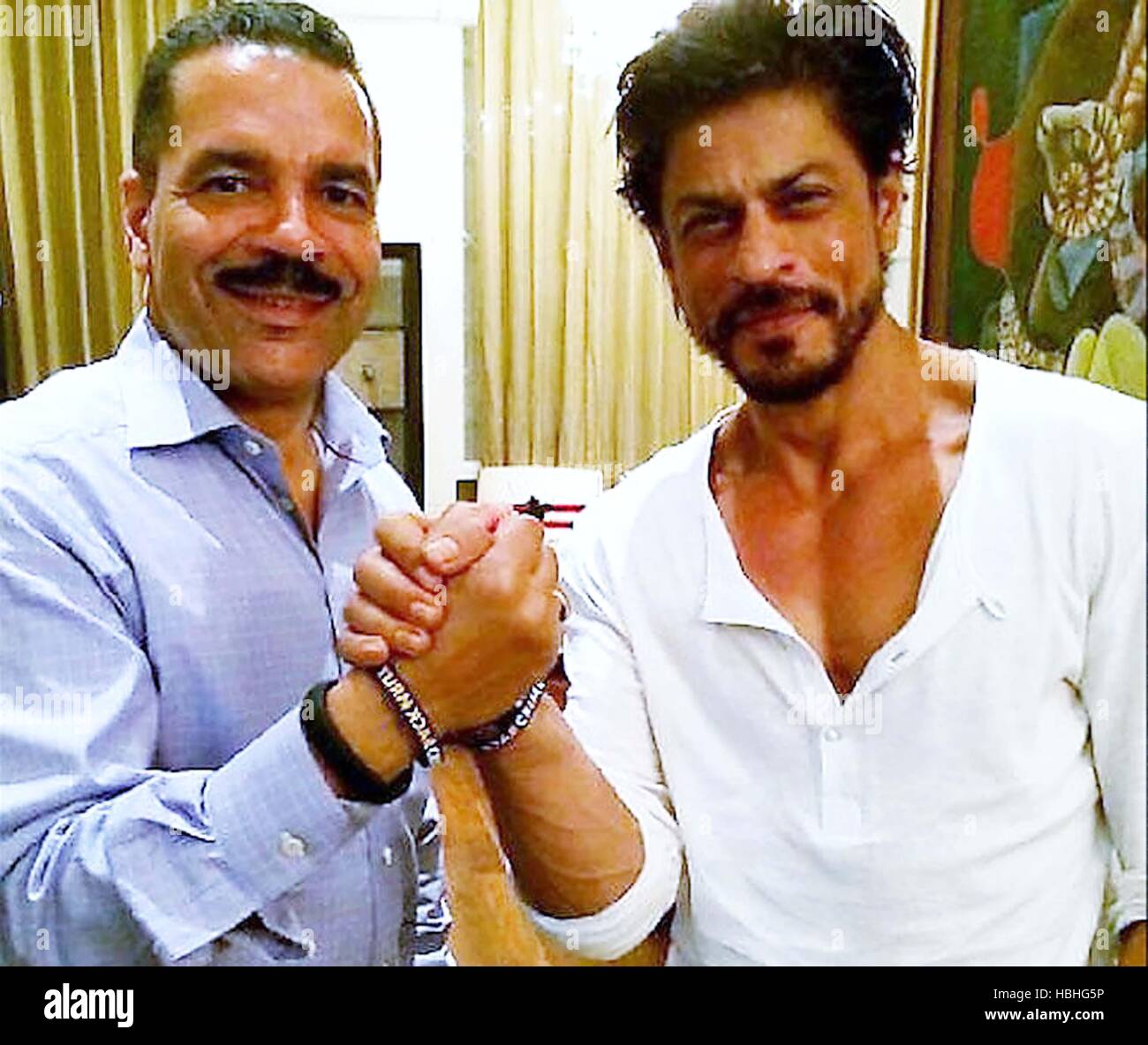 Ronald K Noble, INTERPOL Secretary General, arms wrestling with Indian Bollywood actor Shah Rukh Khan in London, England, UK Stock Photo