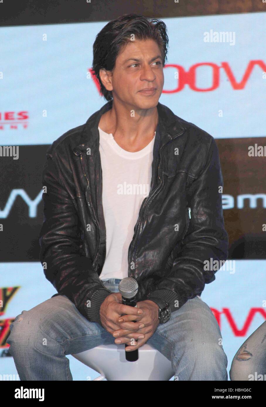 Bollywood actor Shah Rukh Khan portrait, white tshirt, black jacket, microphone in hand, at movie Happy New Year event in Mumbai, India Stock Photo
