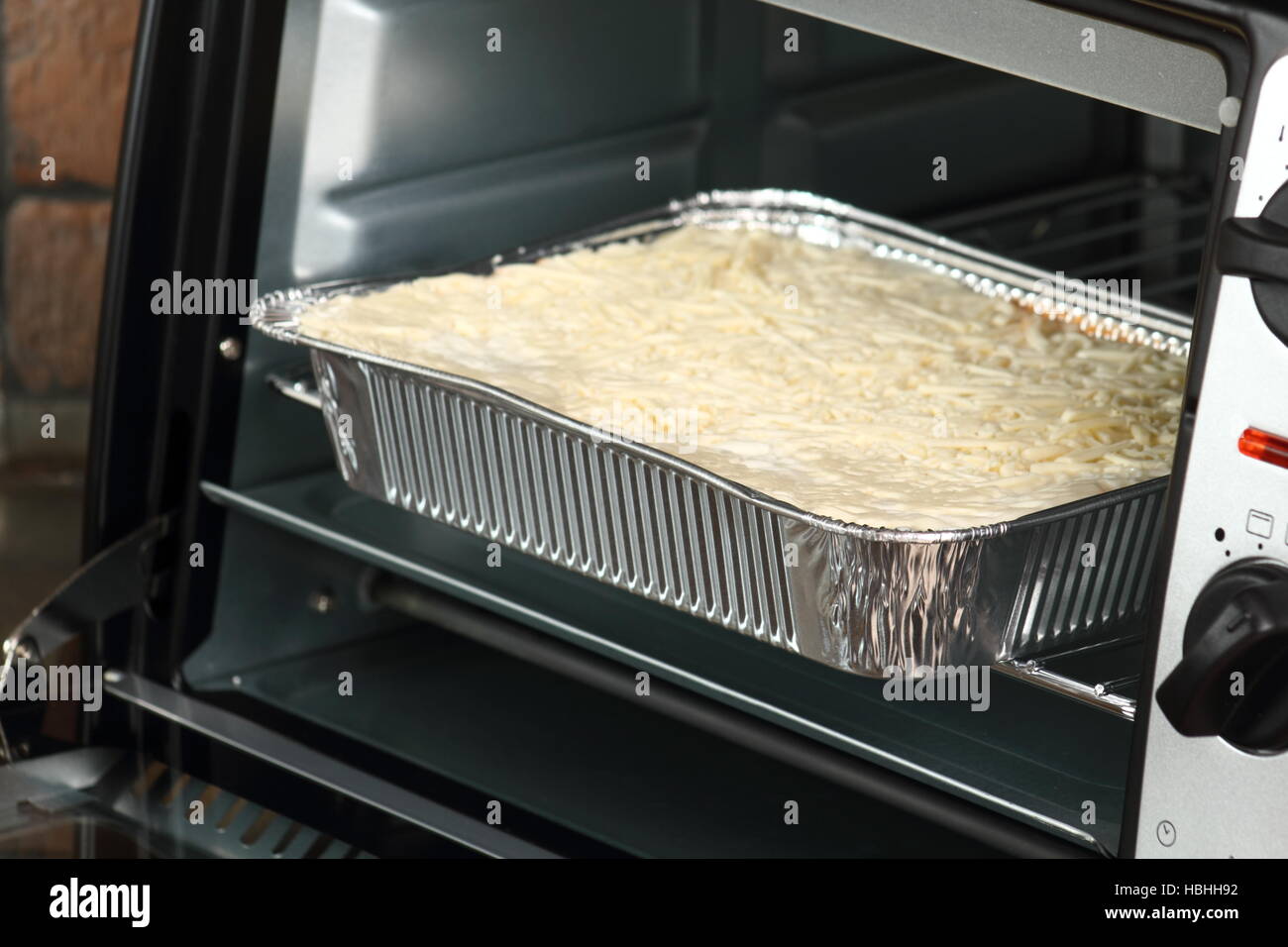 Baking Lasagne Bolognese in Disposable Foil Dish in Electric Oven Stock