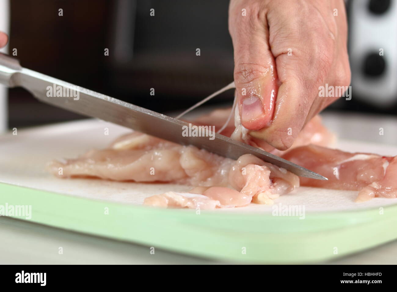 Chef removing tough membrane from chicken fillet. Making Chicken and
