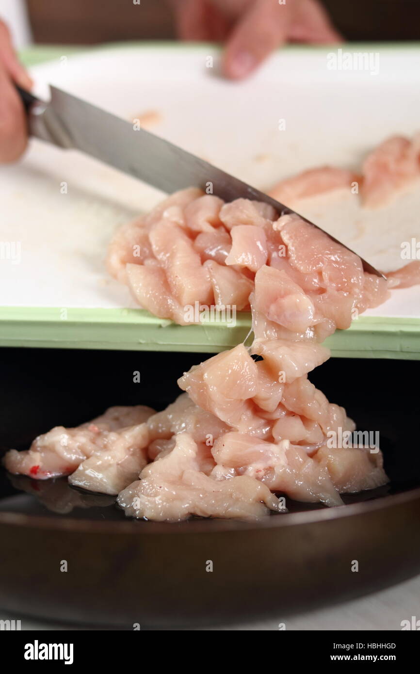 Adding diced chicken fillet into frying pan. Making Chicken and Egg
