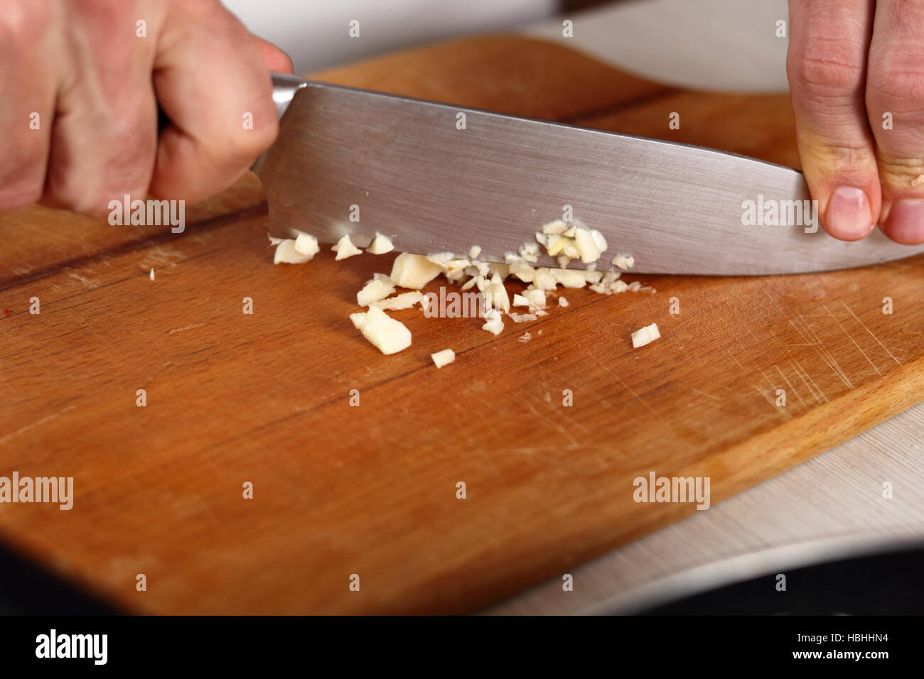 Chef mincing garlic with knife. Making Chicken and Egg Galette Series
