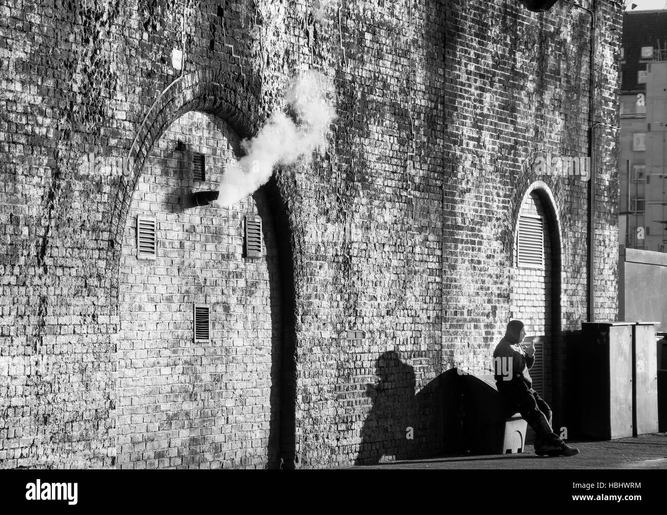 Man sitting smoking underneath the arches, Waterloo, London Borough of Lambeth, Greater London, England, United Kingdom Stock Photo
