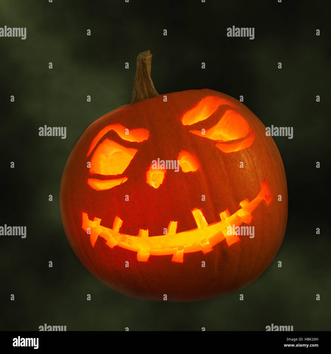 Carved pumpkin face for Halloween with smoky green background Stock ...