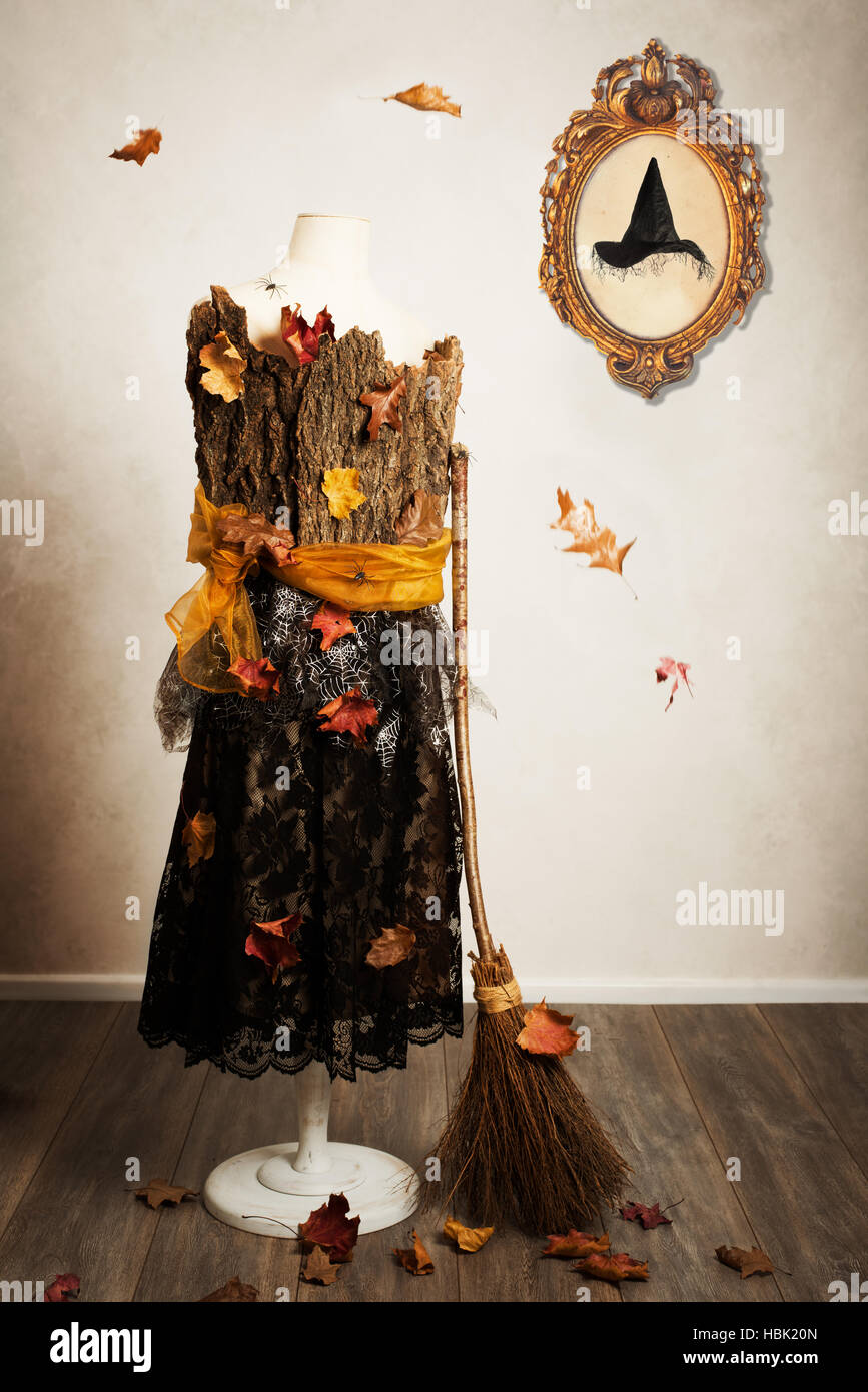 Mannequin dressed for the fall with witches broom and hat in picture frame on the wall Stock Photo