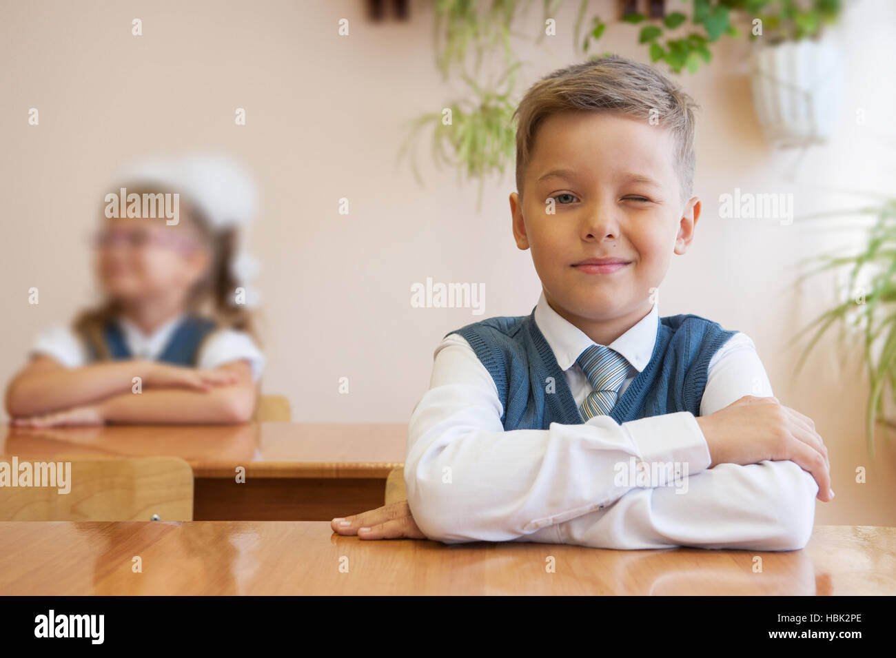 Happy schoolboy sitting at desk Stock Photo - Alamy