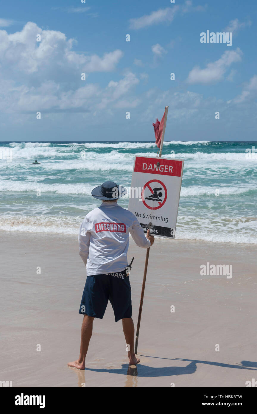Lifeguard holding swimming danger sign on Surfers Paradise Beach, Surfers Paradise, City of Gold Coast, Queensland, Australia Stock Photo