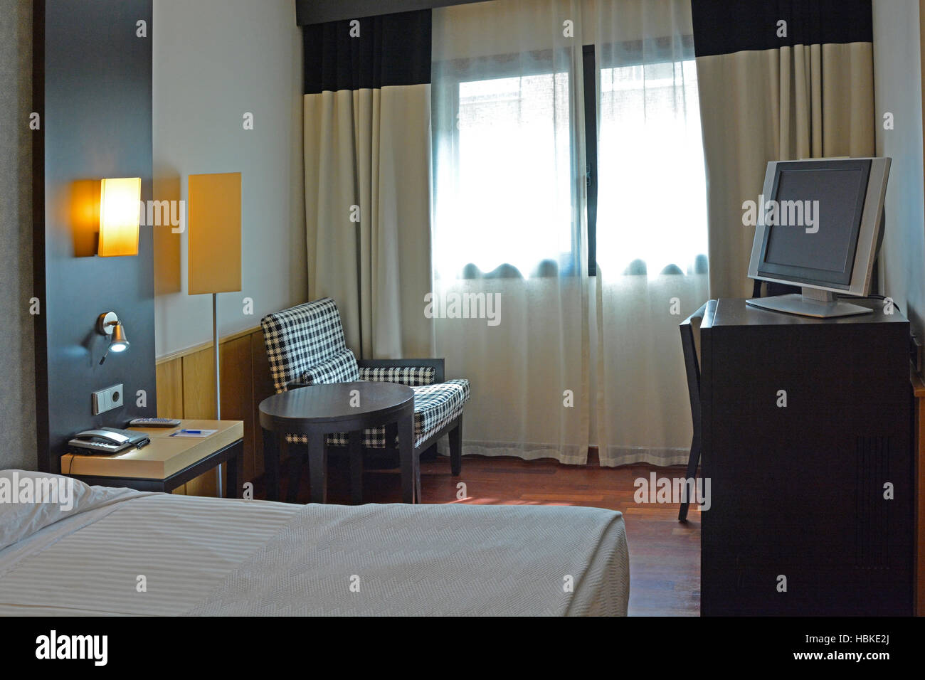Modern hotel room, double bed with bedside tables, telephone and lamps. Valencia, Spain Stock