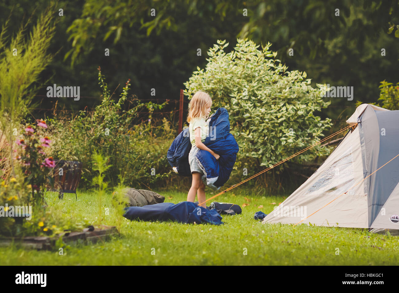 Young girl preparing tent for camping Stock Photo