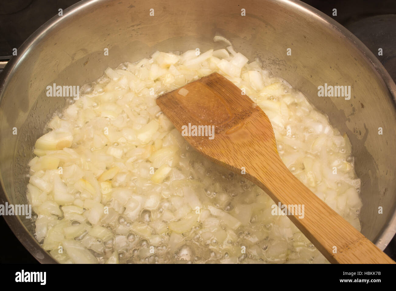 Frying onion in a pan Stock Photo