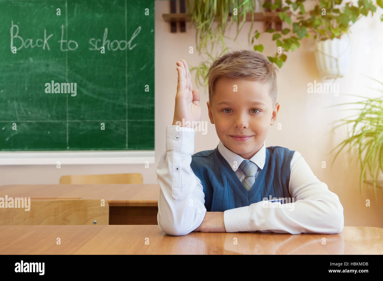Happy schoolboy sitting at desk Stock Photo - Alamy