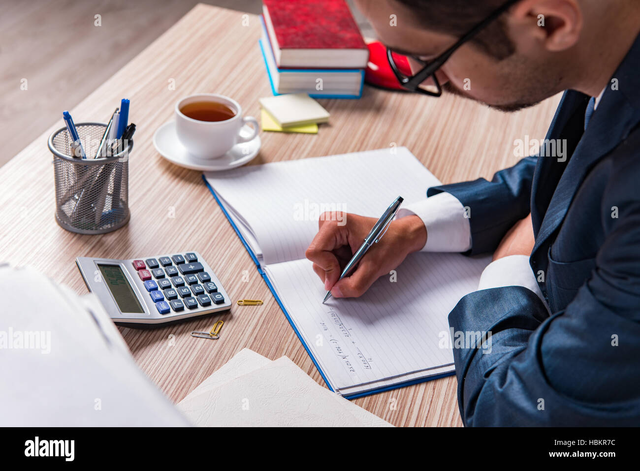 Businessman writing report in the office Stock Photo - Alamy