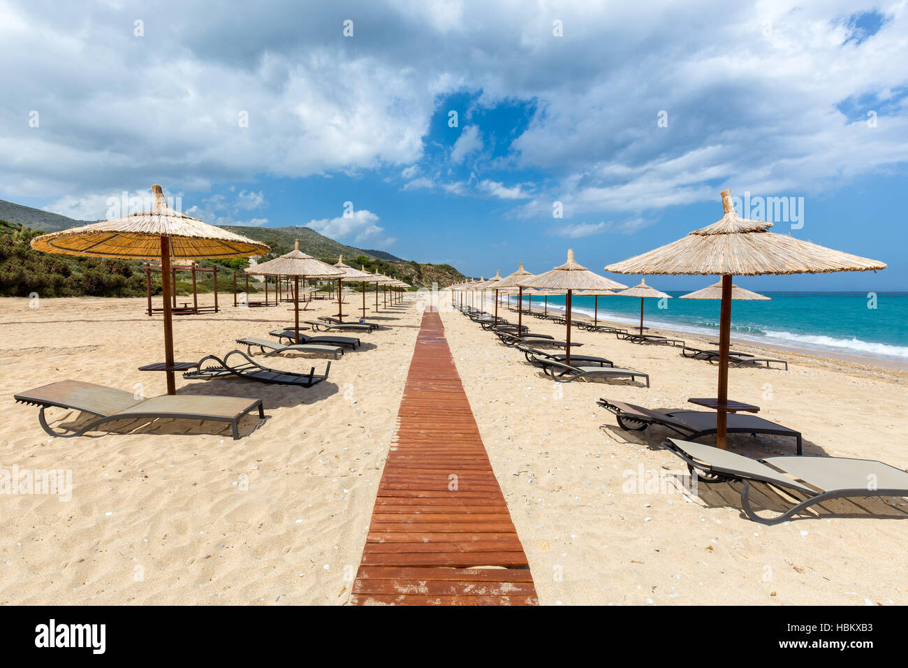 Beach umbrellas and loungers at greek sea Stock Photo