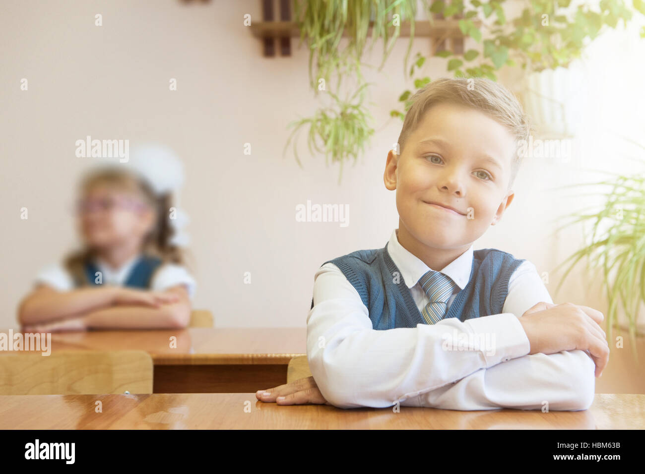 Happy schoolboy sitting at desk Stock Photo - Alamy