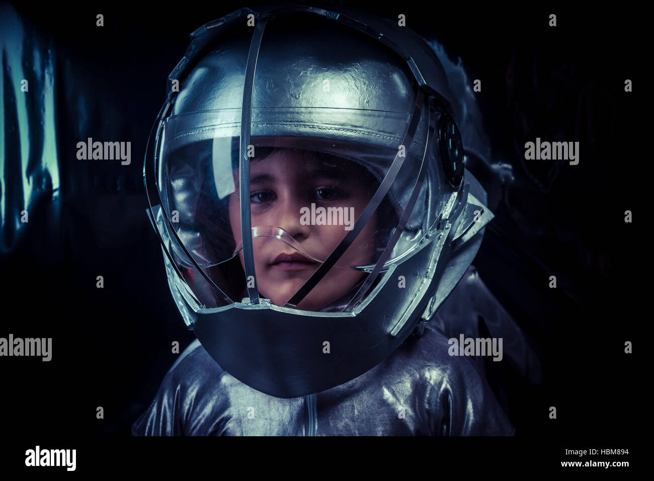Boy playing to be an astronaut with space helmet and metal suit Stock
