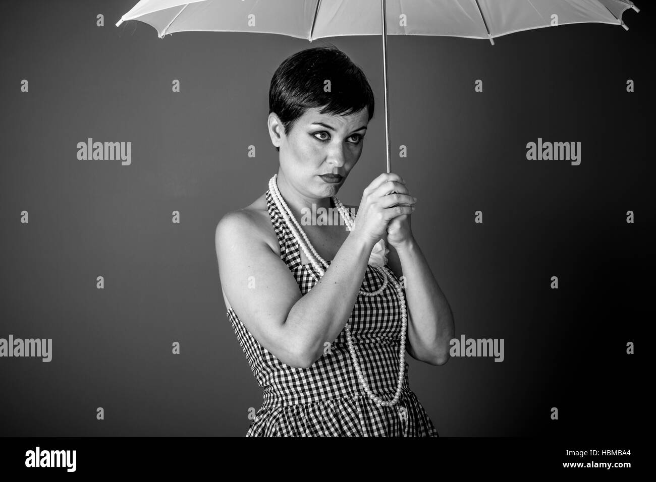 Cheerful girl vintage 50s dress with white umbrella over blue ...