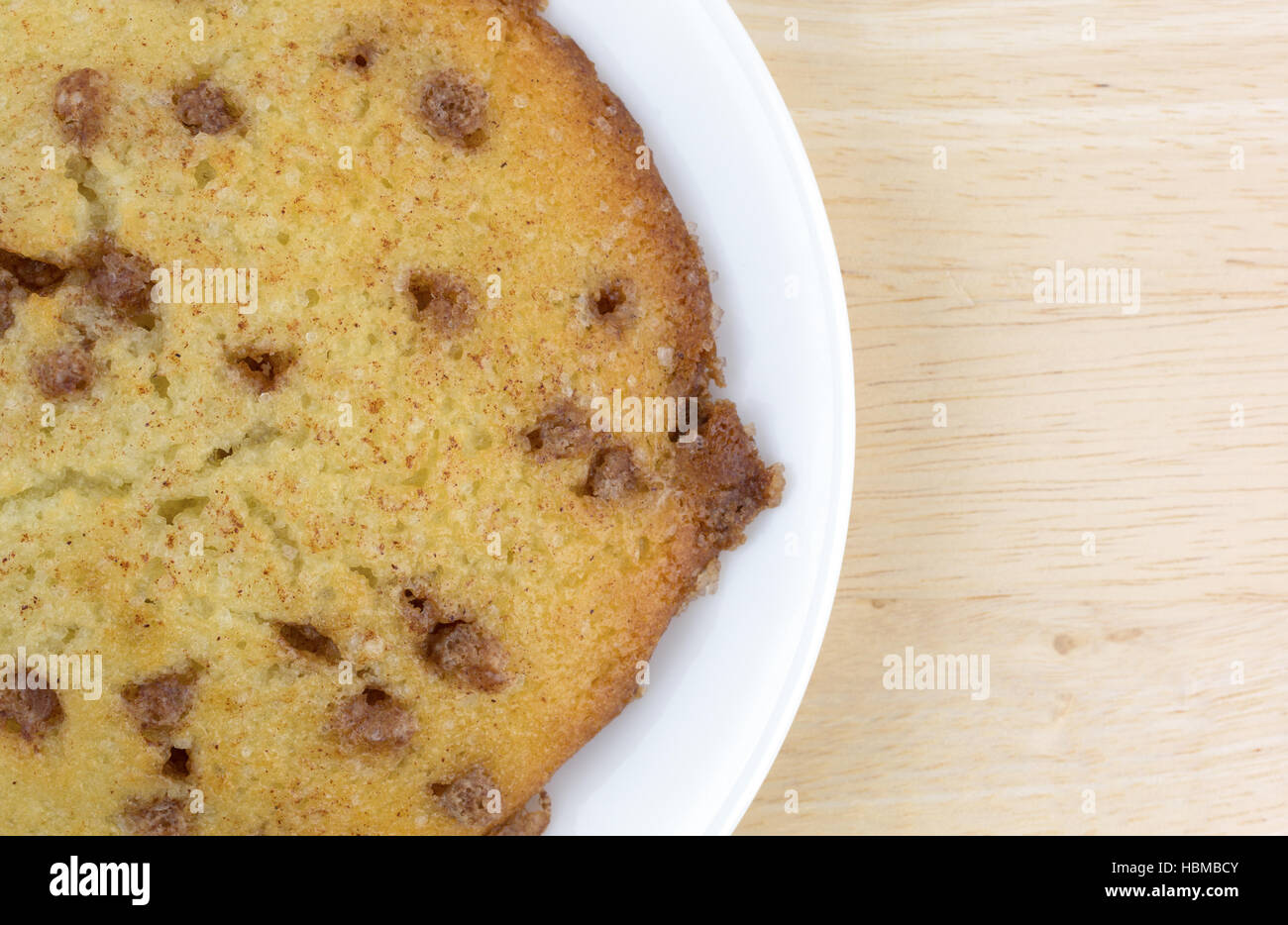 Top close view of a apple spice muffin top on a white plate atop a wood table. Stock Photo