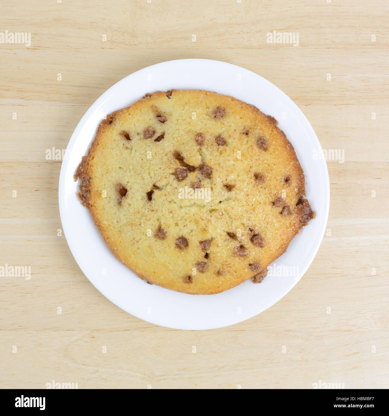 Top view of a apple spice muffin top on a white plate atop a wood table. Stock Photo