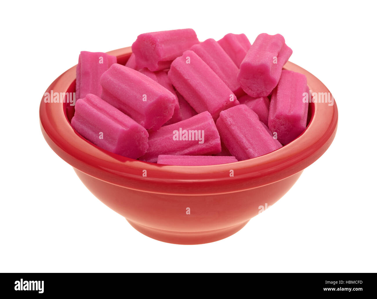 A small red bowl filled with pink bubble gum isolated on a white background. Stock Photo