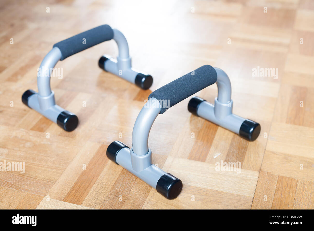 A pair of plastic push up bar on the wooden floor Stock Photo