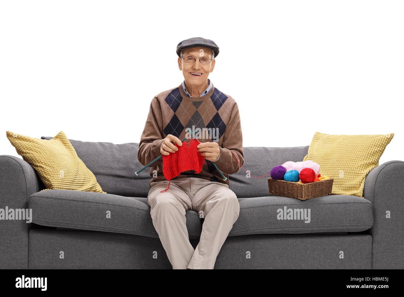 Senior sitting on a couch and knitting isolated on white background ...