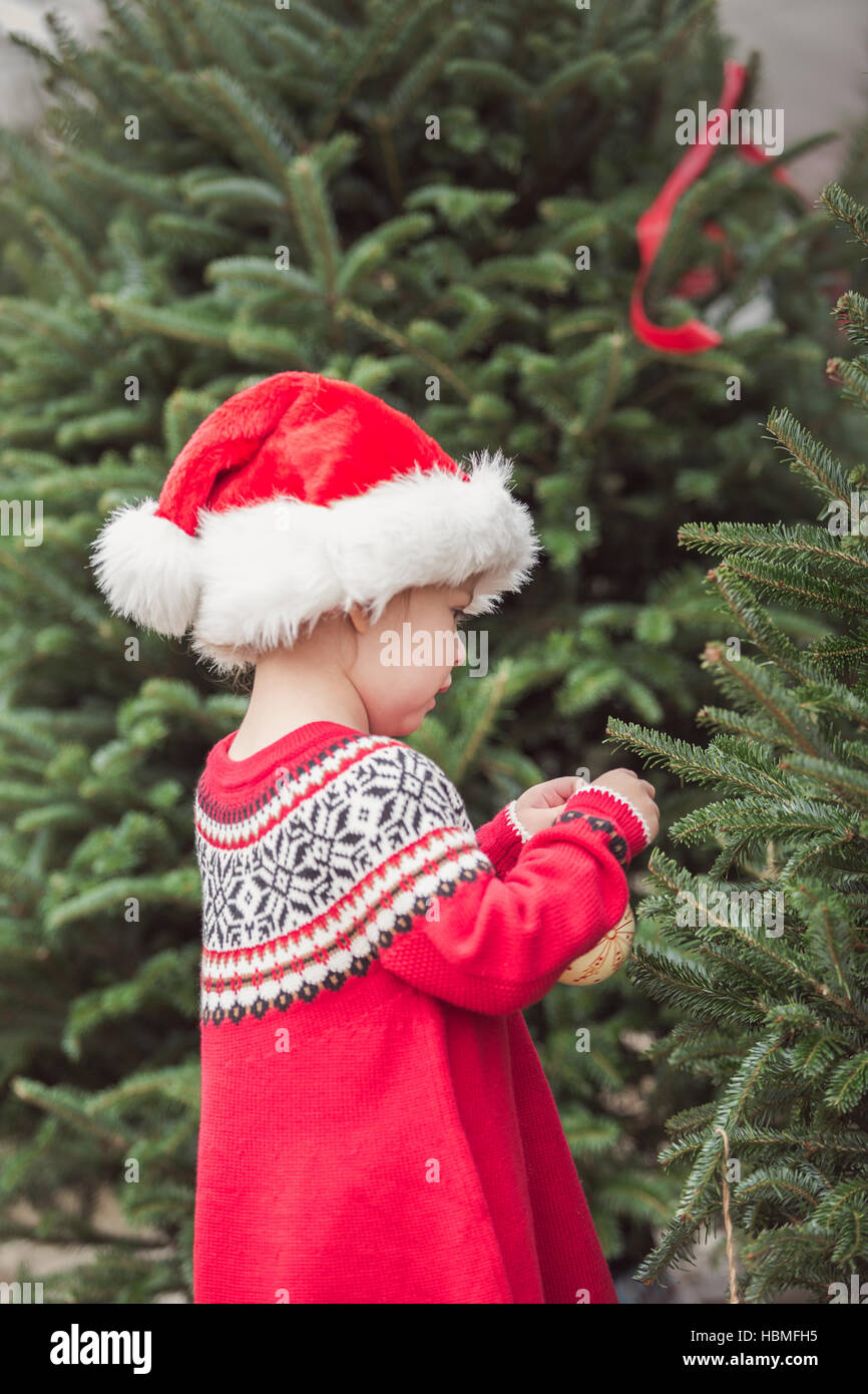 Little girl in red dress on the Christmas tree farm Stock Photo - Alamy