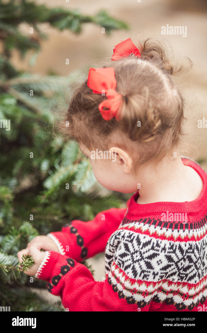 Little girl in red dress on the Christmas tree farm Stock Photo - Alamy