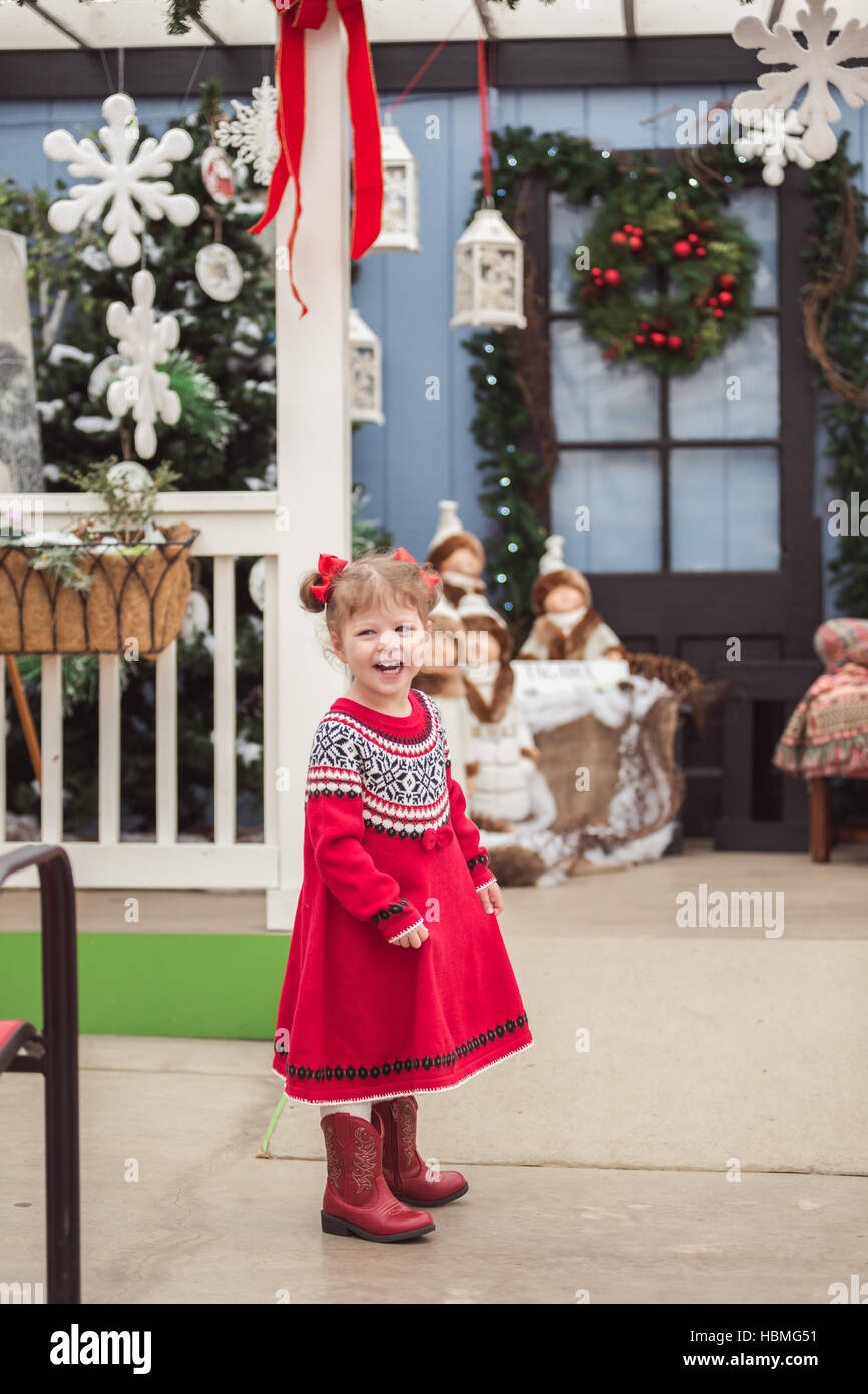 Little girl in red dress on the Christmas tree farm Stock Photo - Alamy