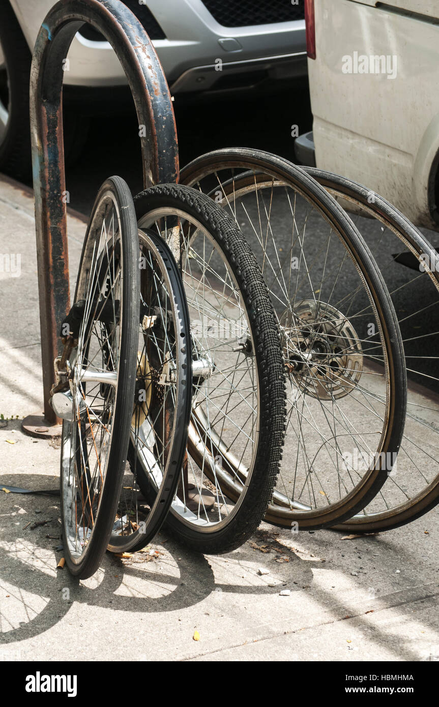 Bicycle wheels locked to pole Stock Photo Alamy
