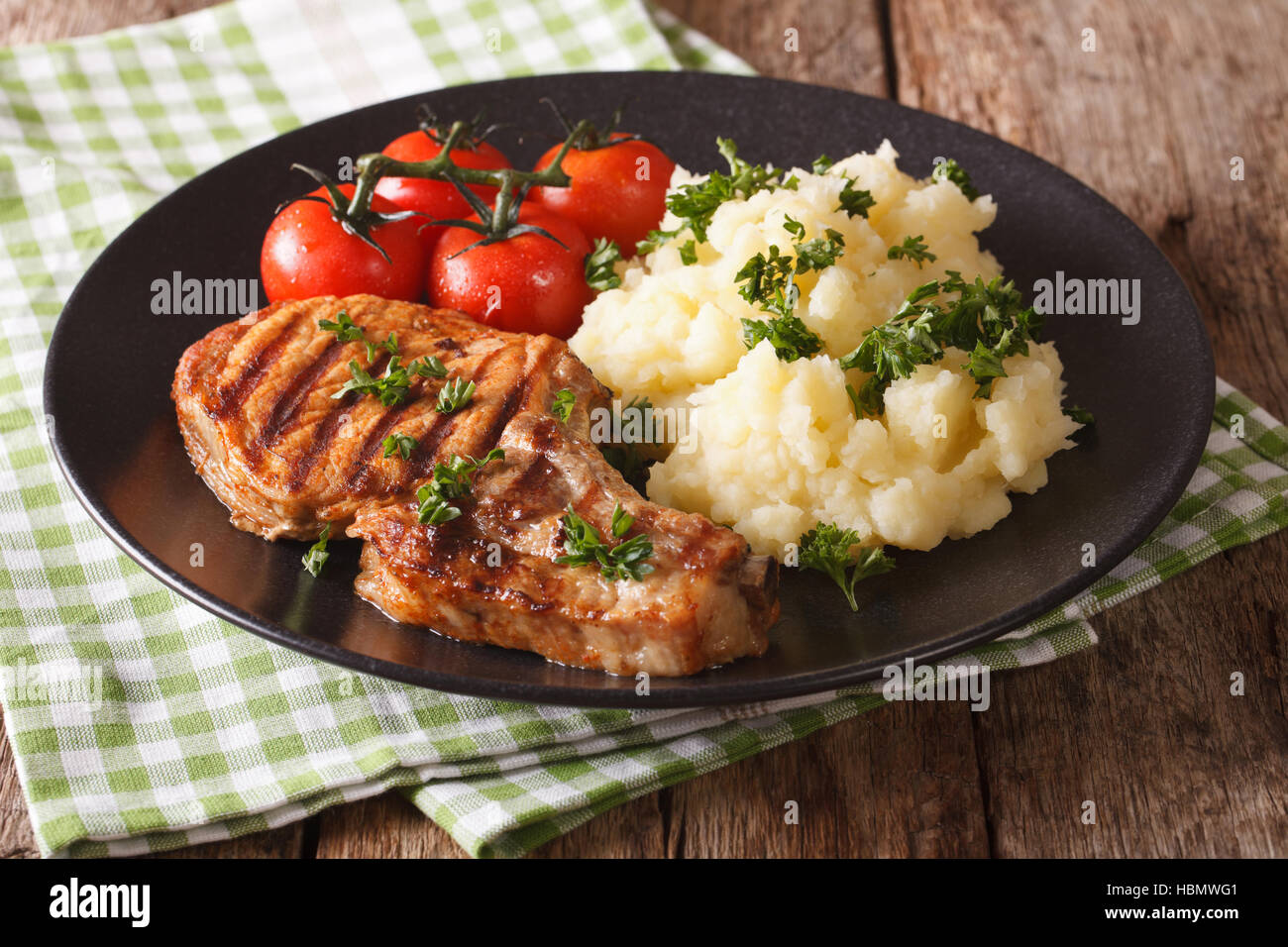 Grilled pork Tbone steak garnished with mashed potatoes and tomato