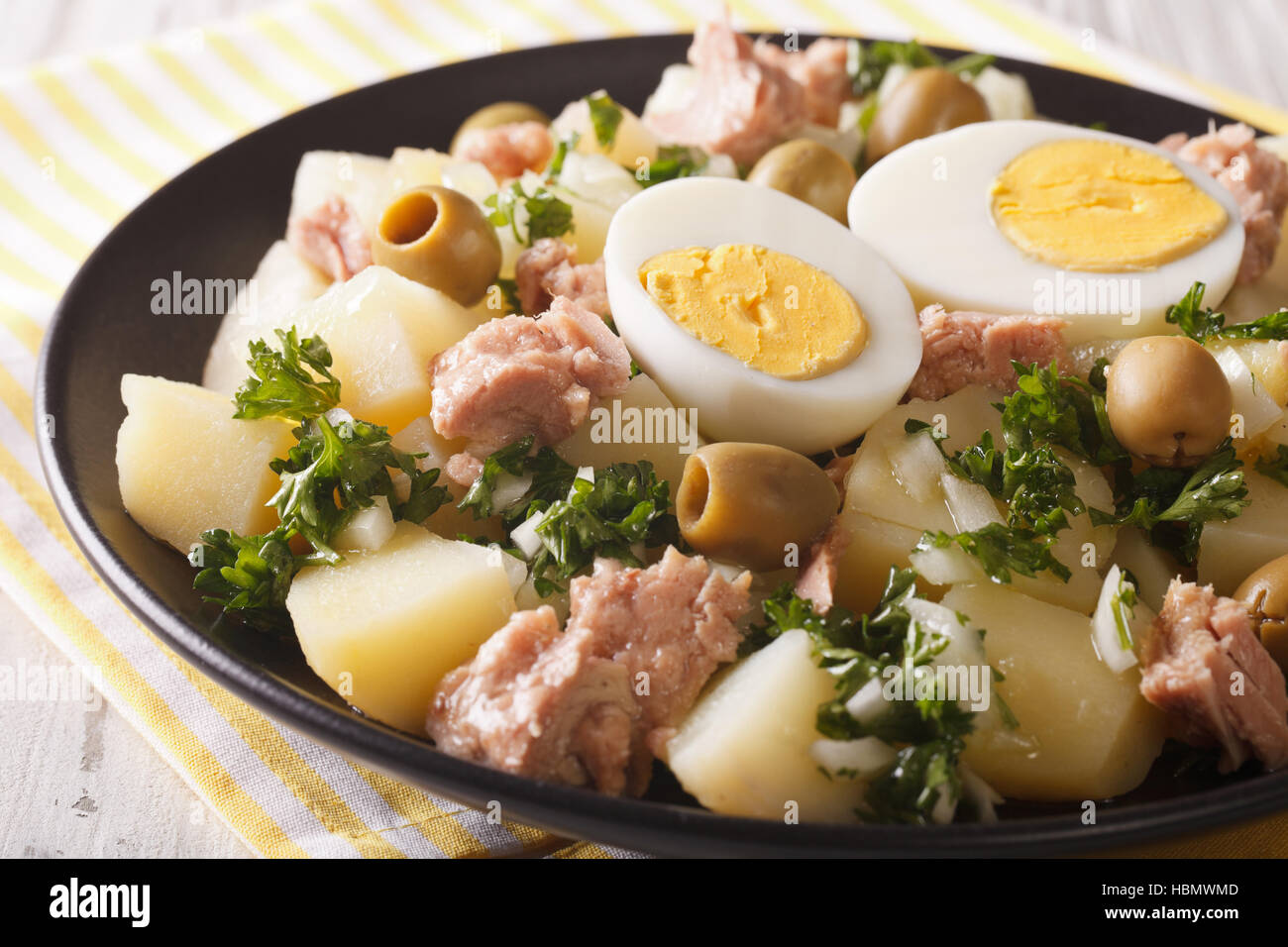 Spanish boiled potatoes with tuna, egg and olives close-up on a plate. horizontal Stock Photo