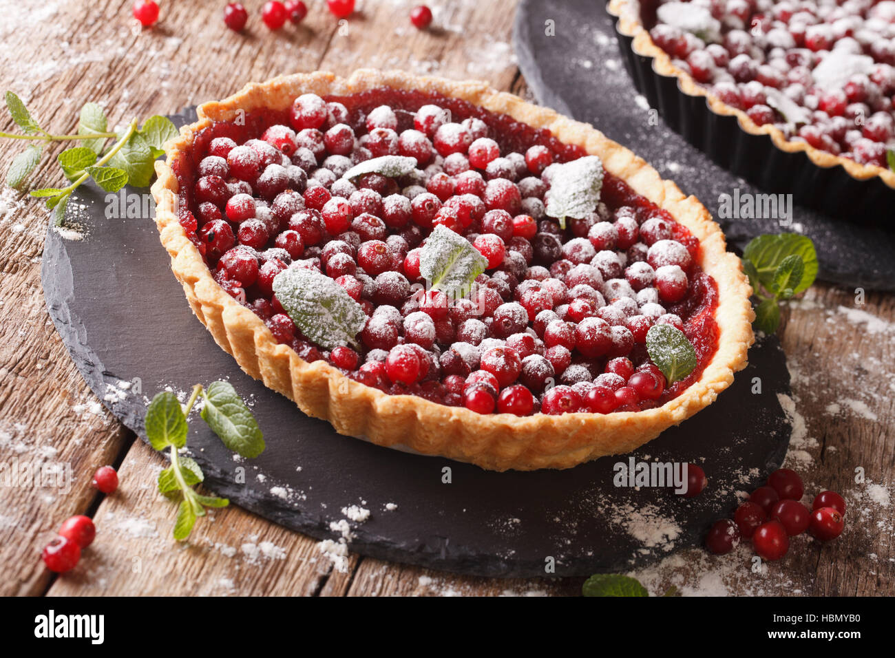 cranberry tart with jam, powdered sugar and mint closeup on the table