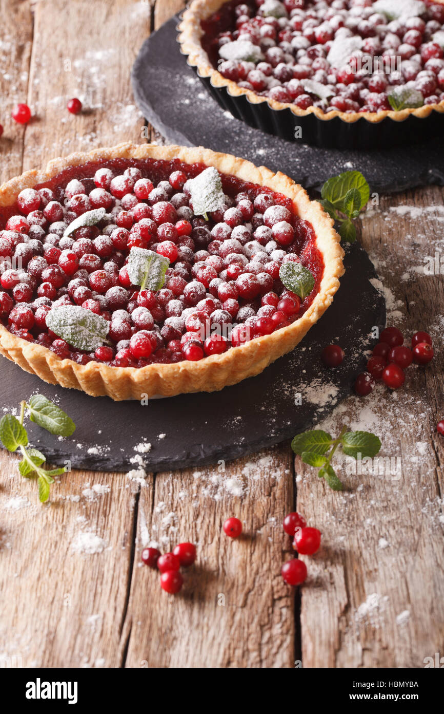 cranberry tart with jam, powdered sugar and mint close-up on the table. vertical Stock Photo