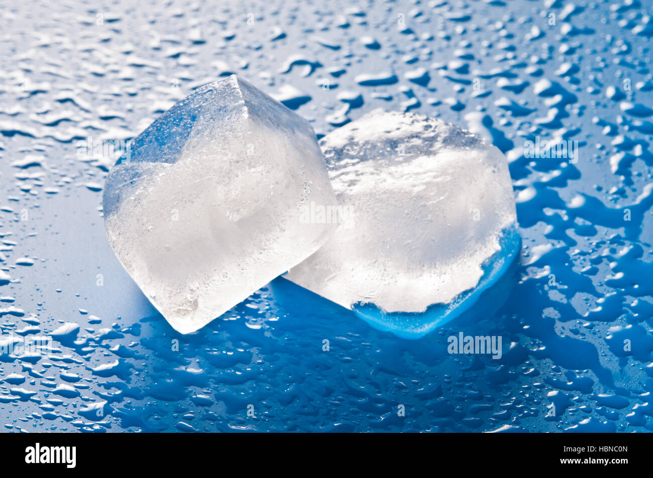 two ice cubes on a wet surface Stock Photo Alamy