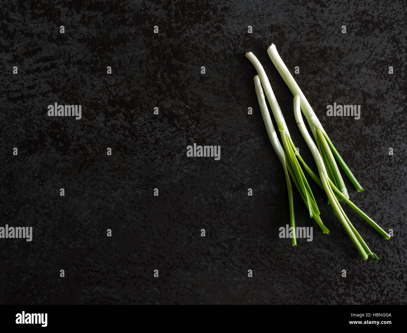 Top view of bunch of green onions on a black stone table Stock Photo ...