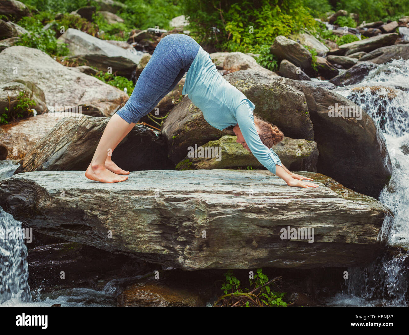 Young sporty fit woman doing yoga oudoors at tropical waterfall Stock ...