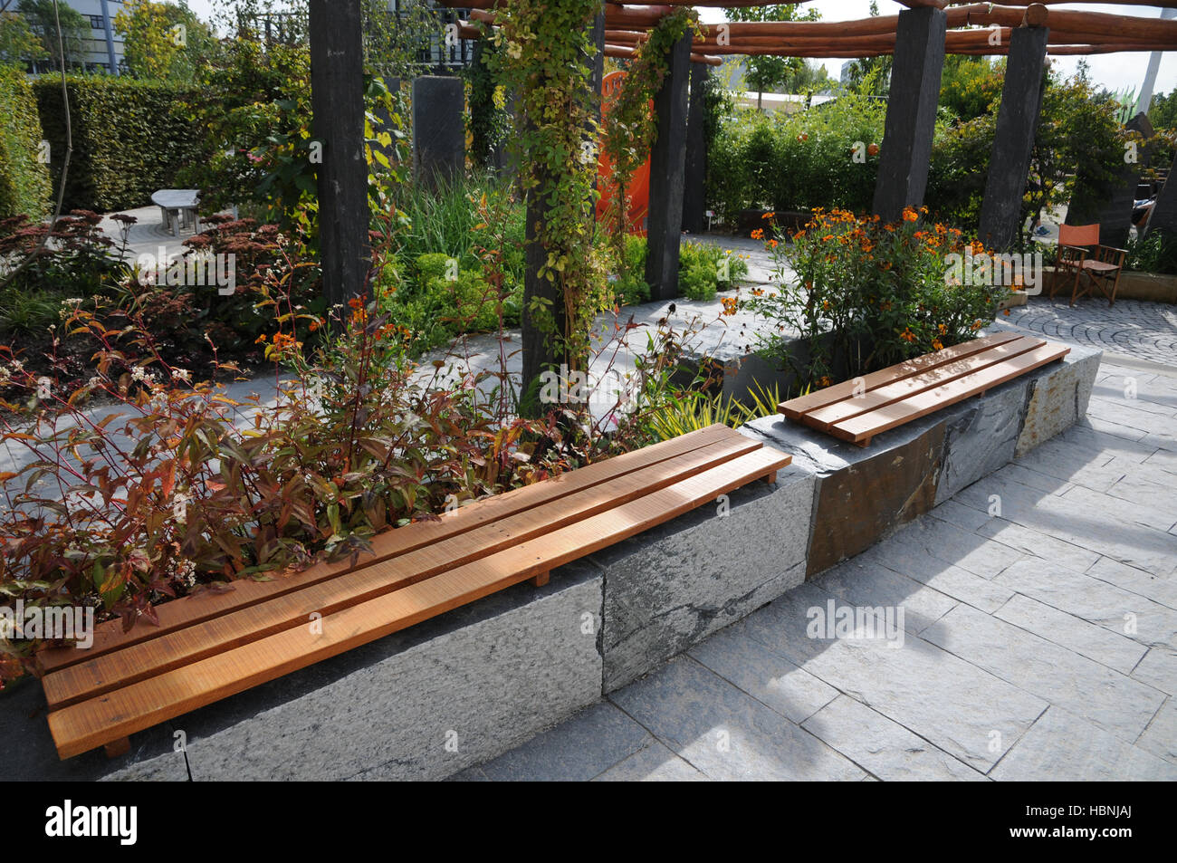 Garden with bench made of stone and wood Stock Photo - Alamy