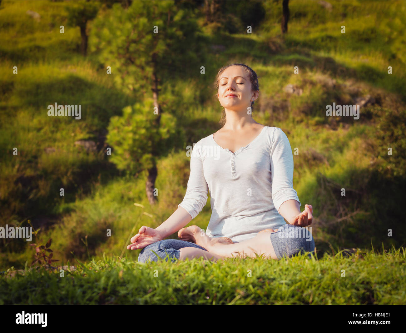 Young sporty fit woman doing yoga Lotus pose oudoors Stock Photo - Alamy