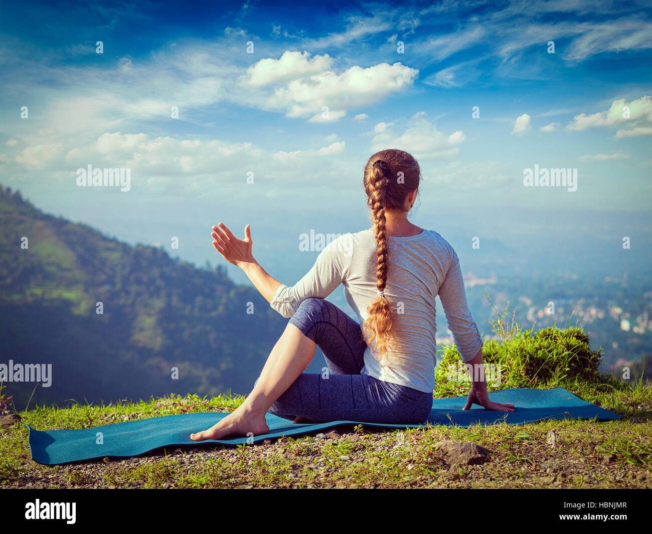 Woman practices yoga asana outdoors Stock Photo