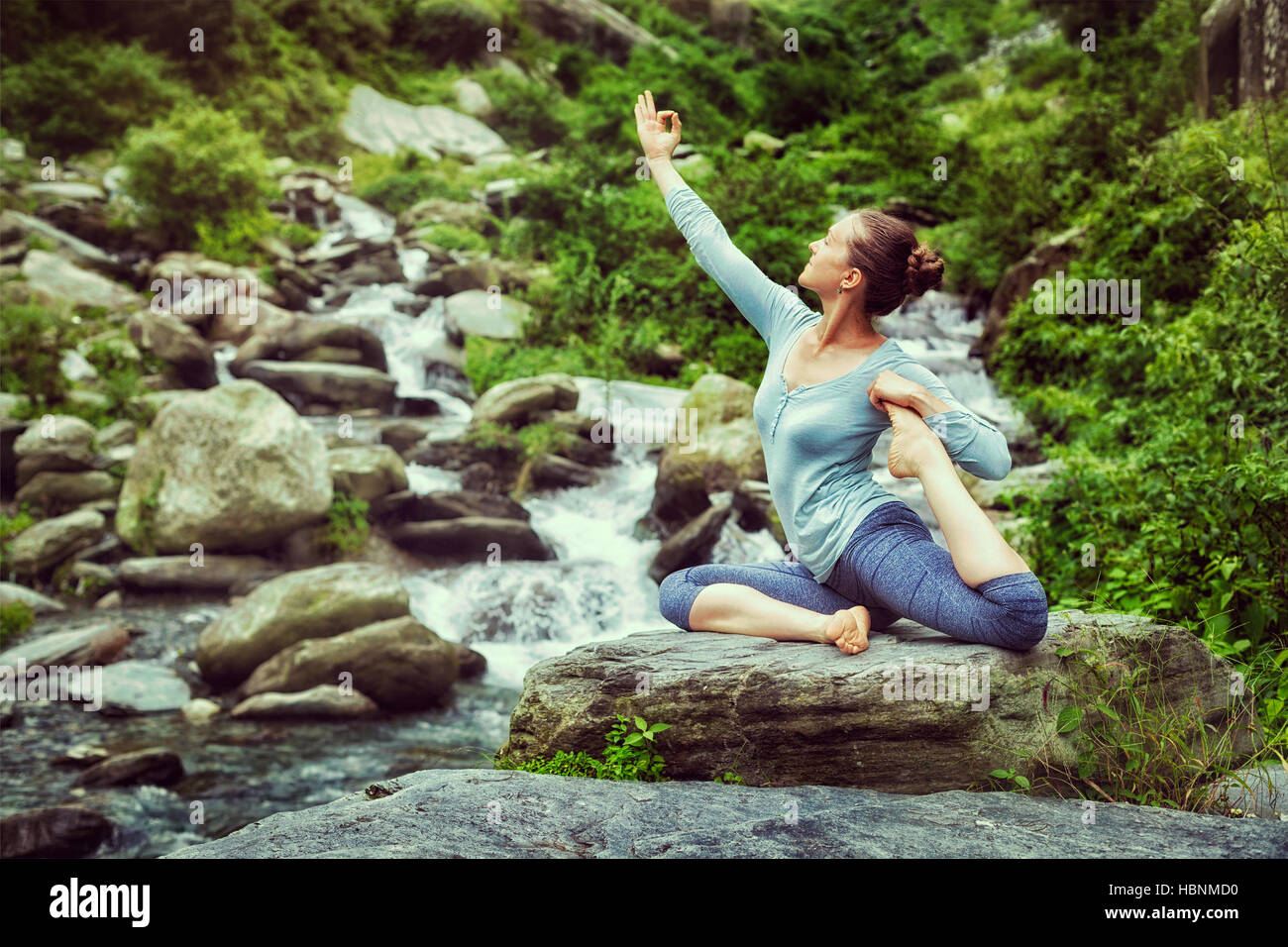 Sorty fit woman doing yoga asana outdoors at tropical waterfall Stock ...