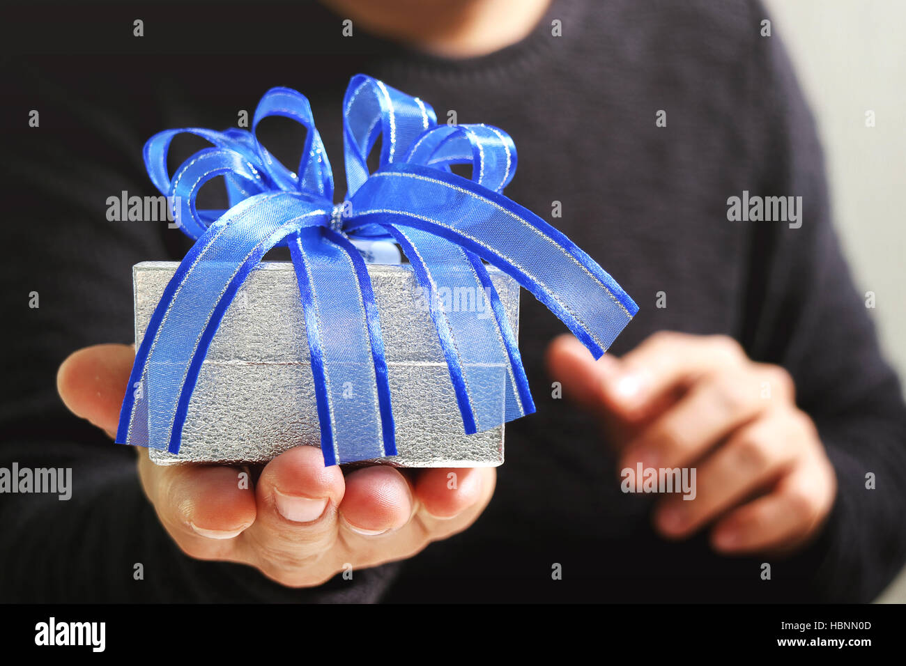 gift giving,man hand holding a gift box in a gesture of giving.blurred
