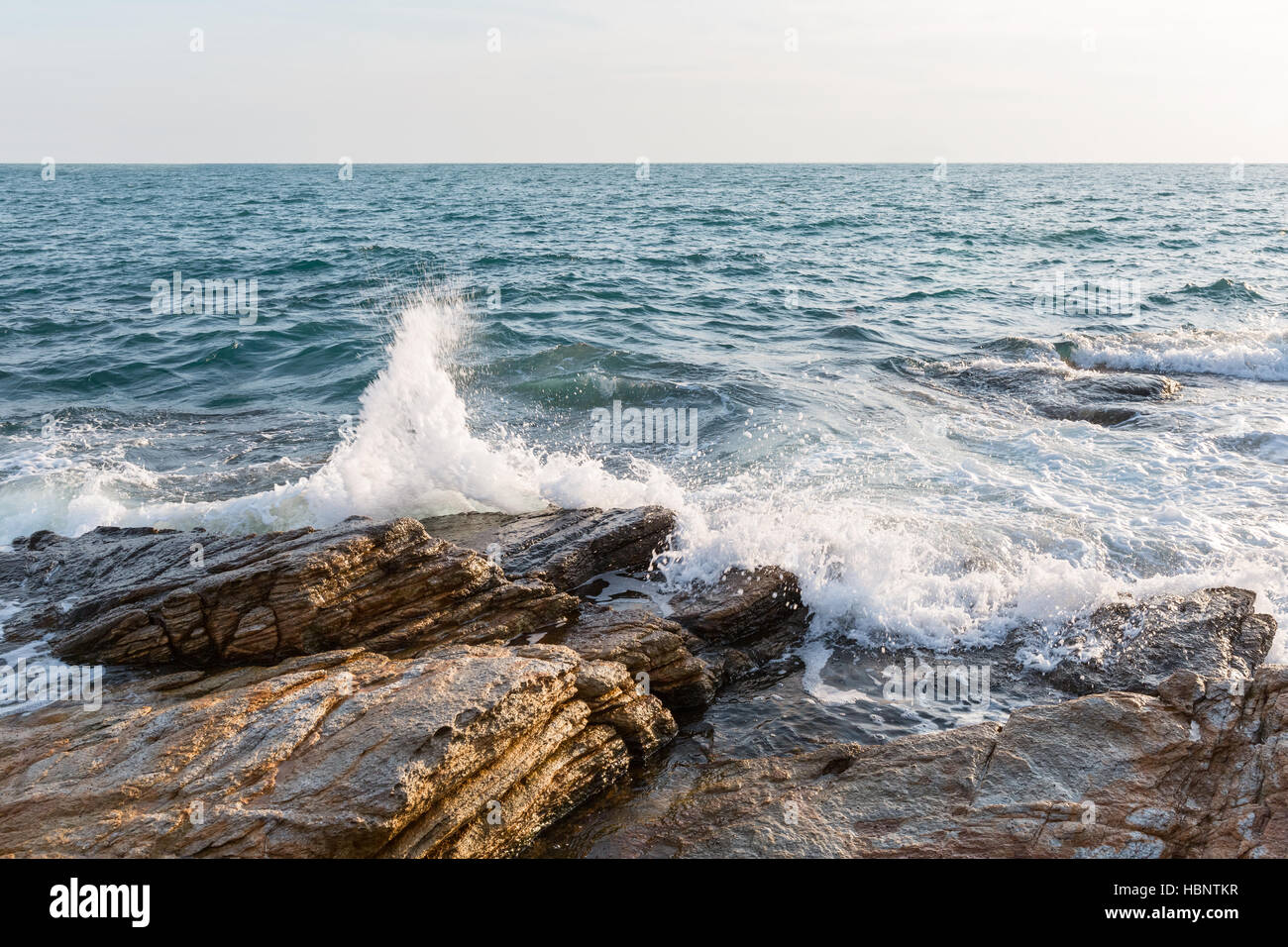 swashing against the sea rocks Stock Photo