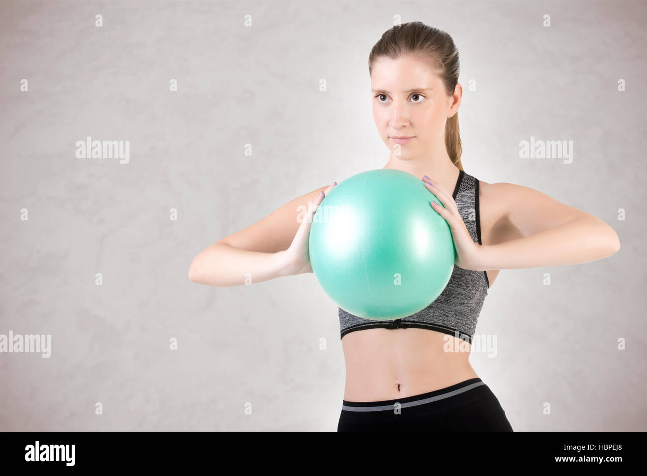 Fit Woman Standing Holding a Pilates Ball Stock Photo - Alamy