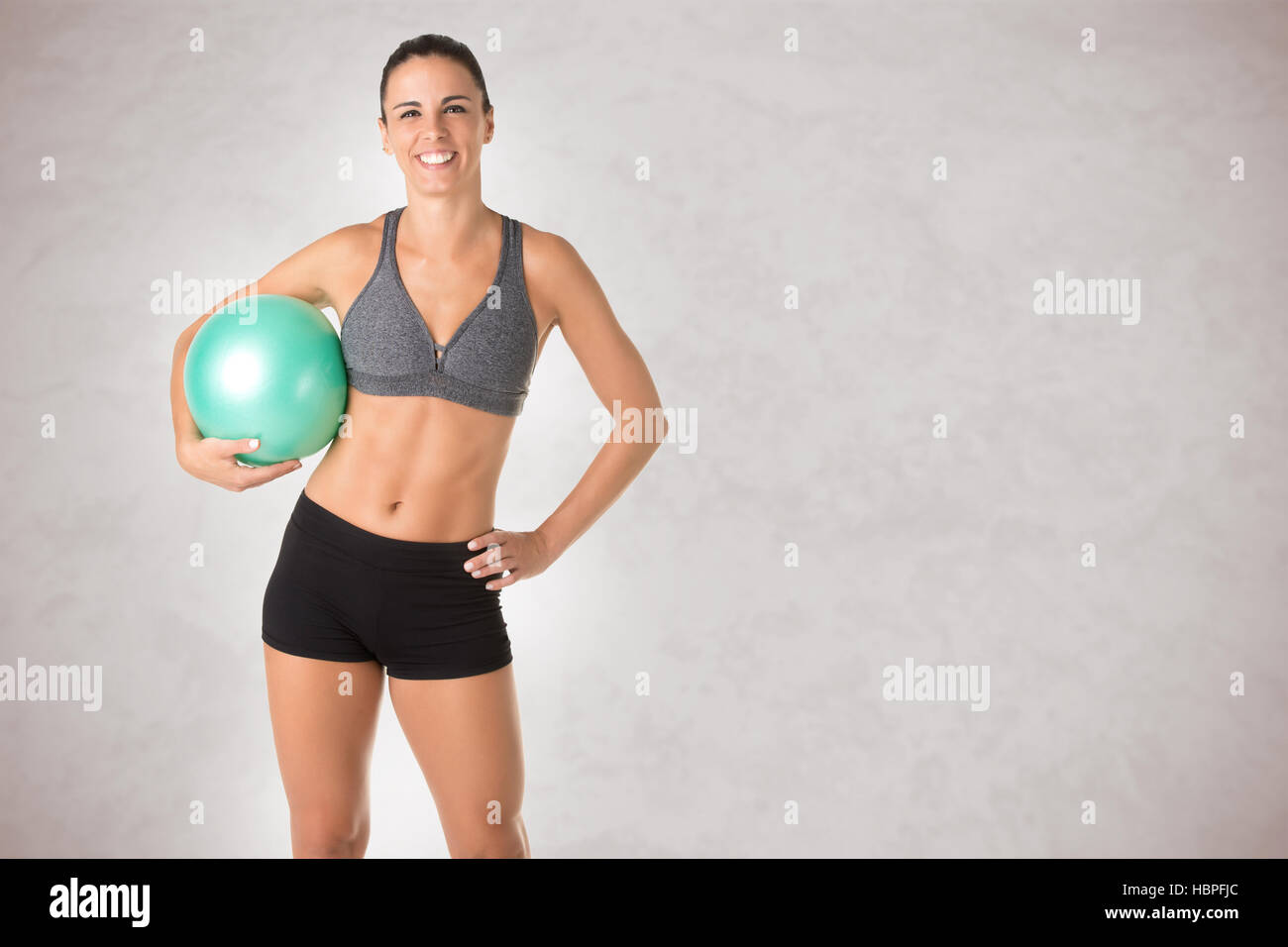 Fit Woman Standing Holding a Pilates Ball Stock Photo