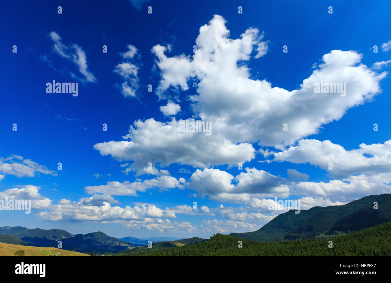 Blue sky with white clouds over mountain Stock Photo - Alamy