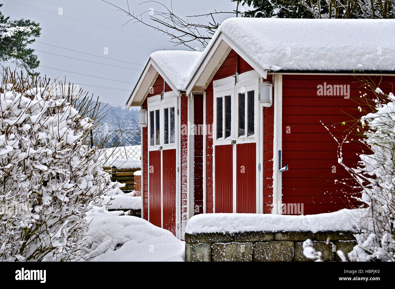 snow covered red wooden garden houses Stock Photo